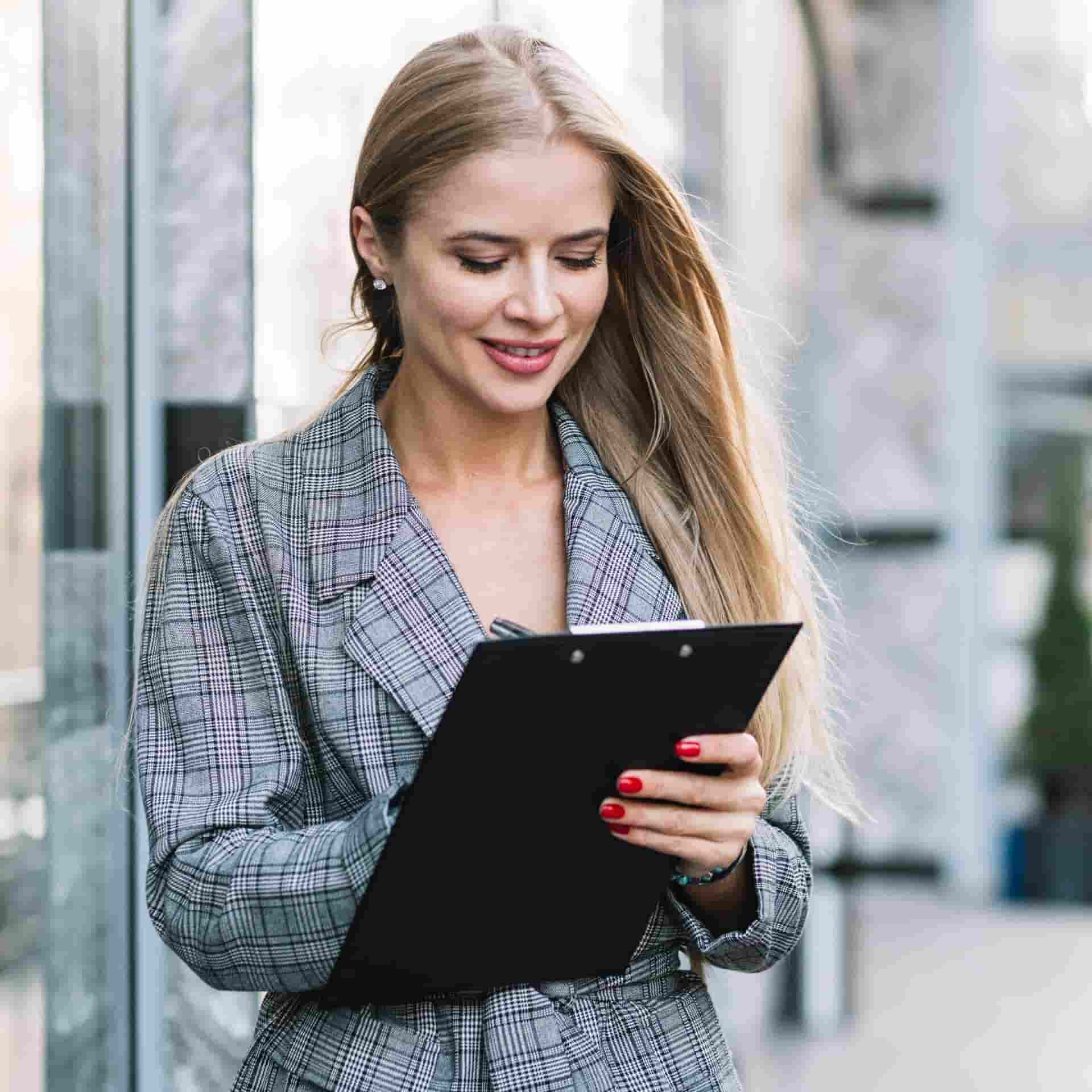 stylish-businesswoman-with-clipboard-city